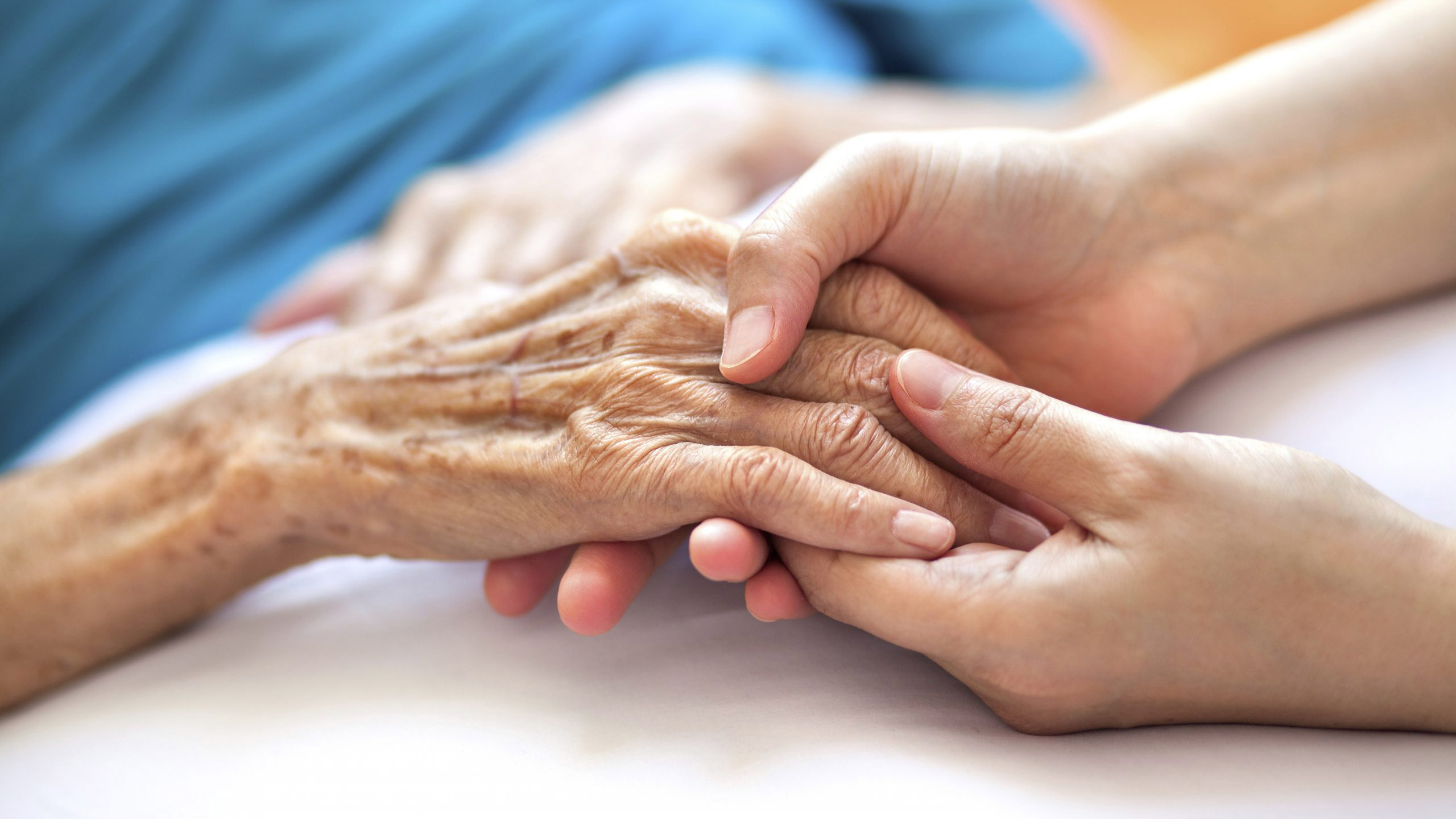 nurse holding elder's hands