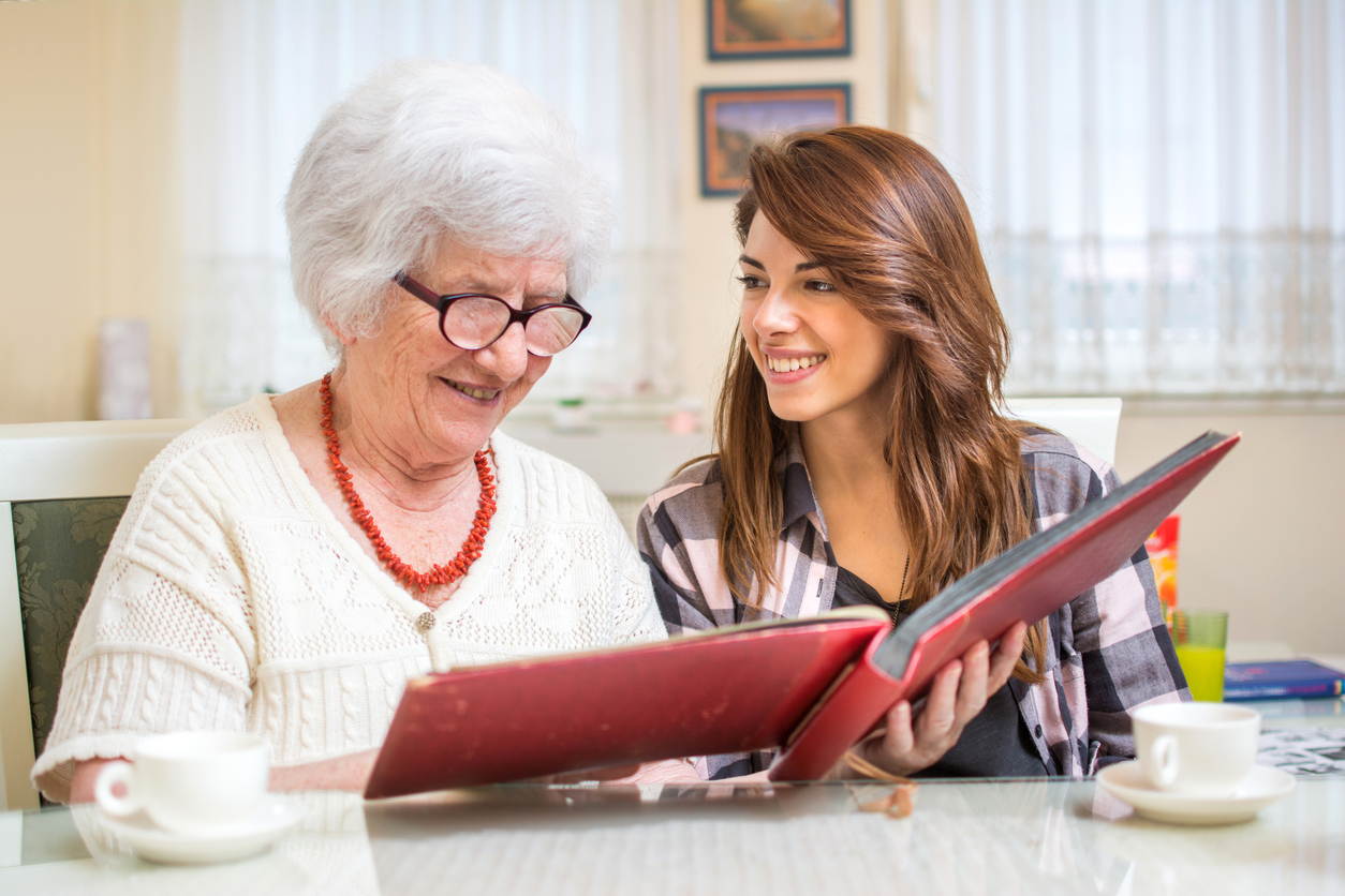 Granddaughter with her grandmother looking at photo album.