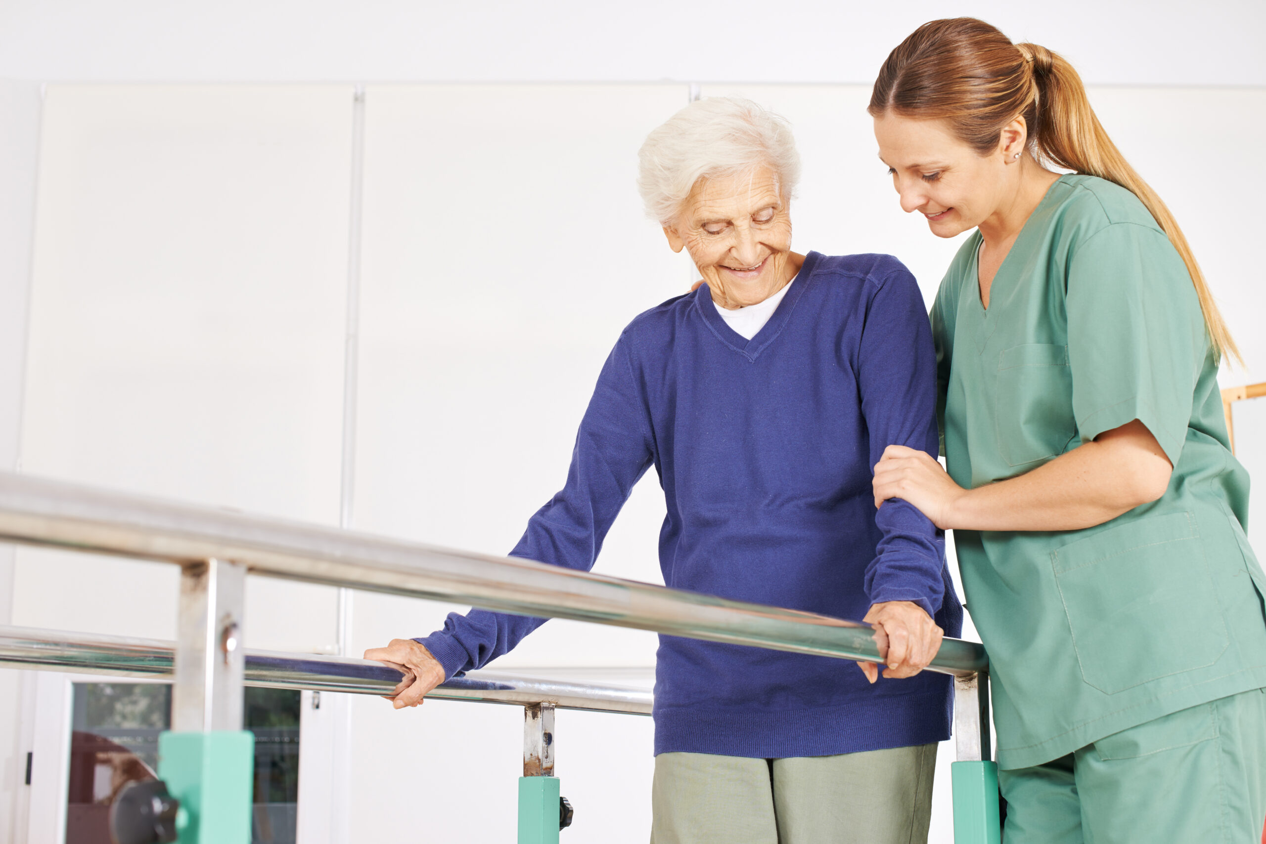 Caregiver helping an elderly woman do physical therapy
